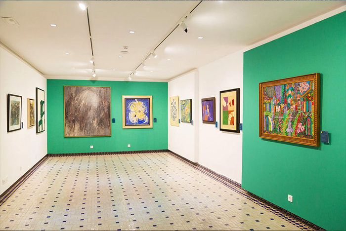 Salle d'exposition colorée du Musée Villa Harris, mettant en avant des œuvres d'art variées dans un environnement lumineux et accueillant